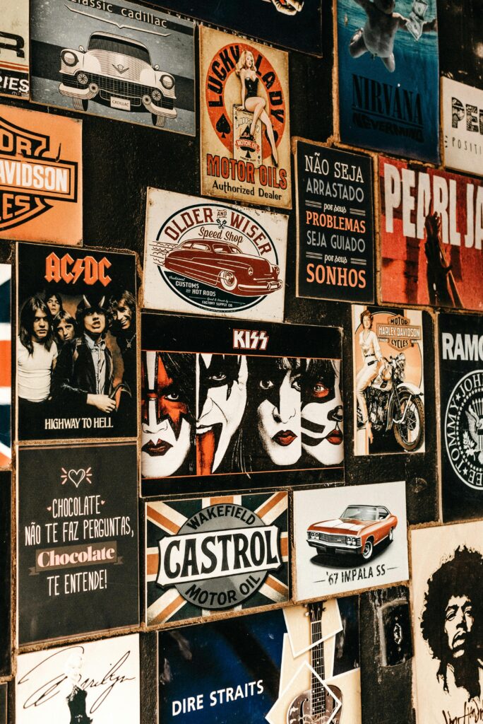 A collage of iconic rock band posters and vintage advertisements on a textured wall.