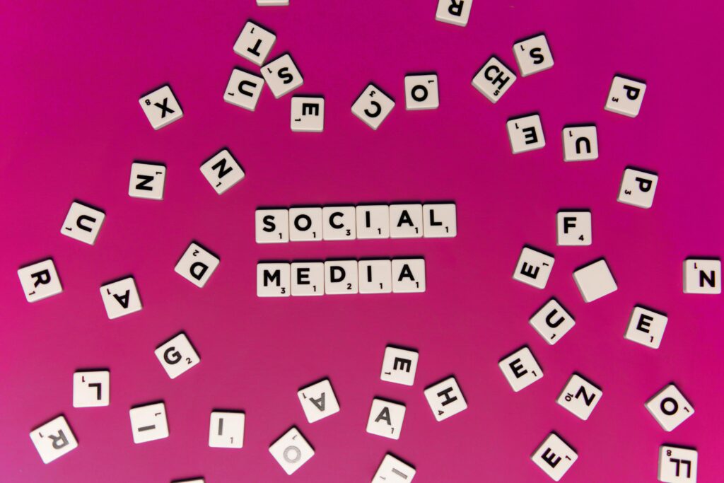 Alphabet tiles forming 'Social Media' on a vibrant pink background, perfect for digital marketing themes.